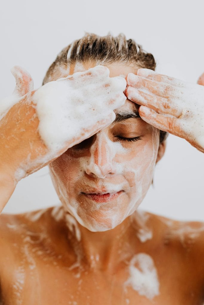 Femme nettoyant son visage avec du savon