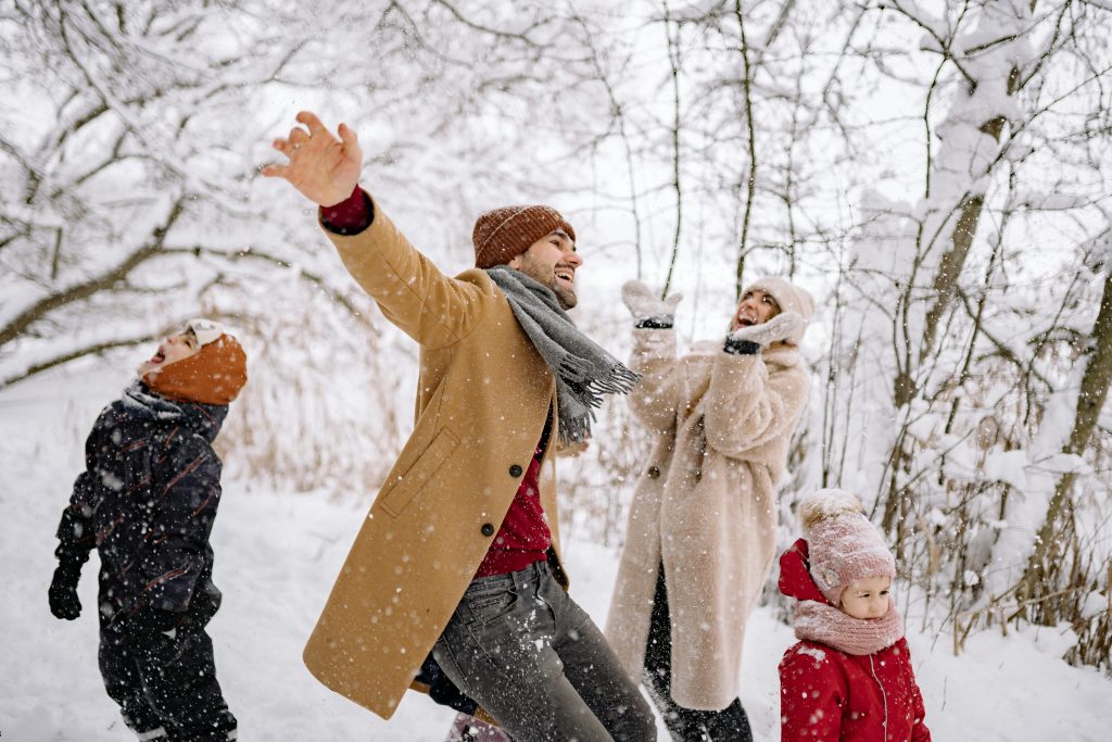 famille jouant avec la neige en foret